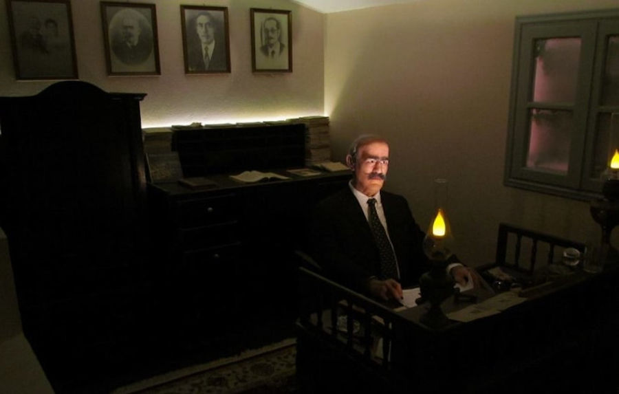 exhibit shows a man reading by lamplight at 'Koutsoyannopoulos Wine Museum'